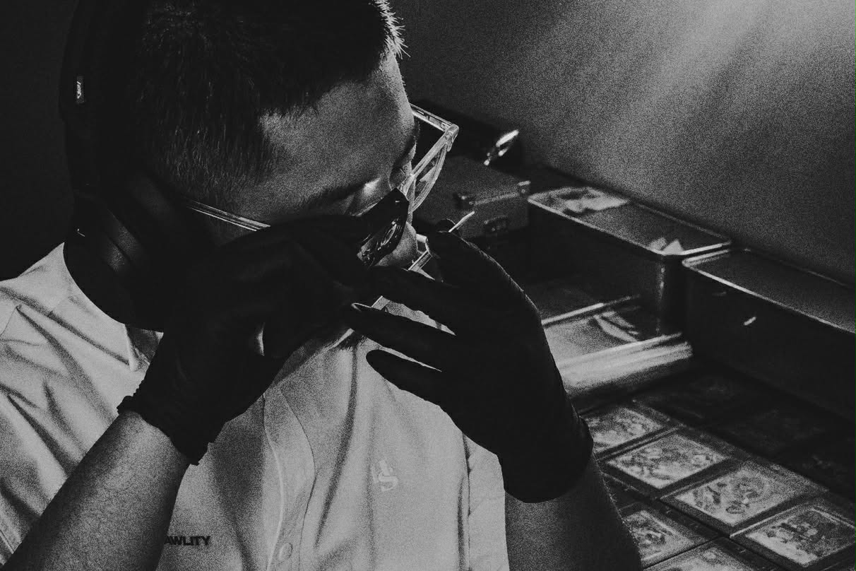 A RAWLITY grader inspecting a card under a loupe