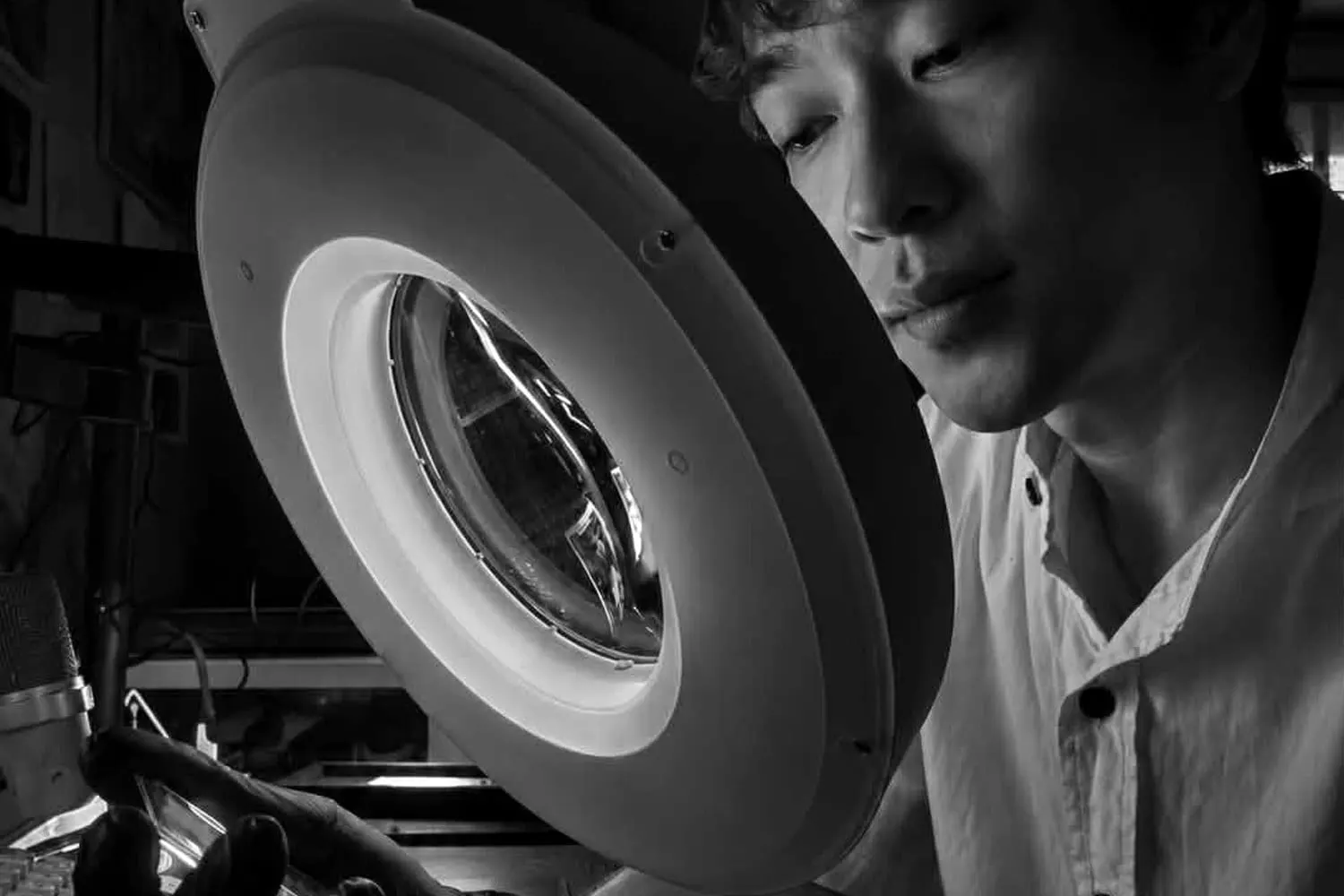 RAWLITY grader examining a card under a magnifier lamp